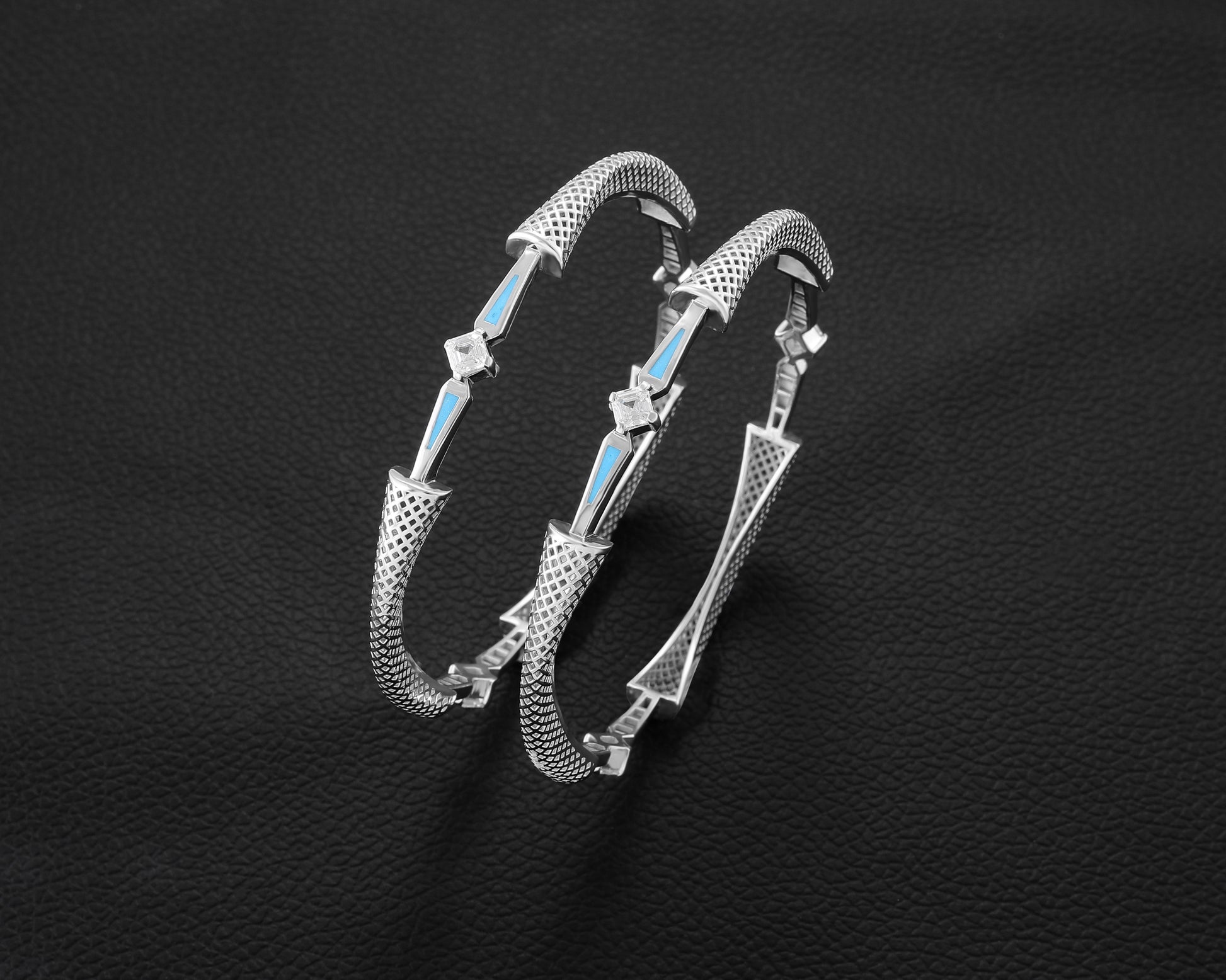 Silver bracelet with blue accents on a black textured background