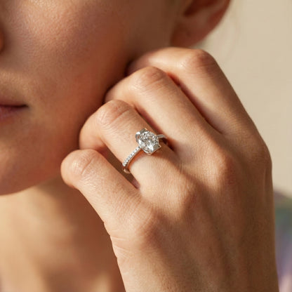 Close-up of a hand wearing a diamond ring with a blurred background