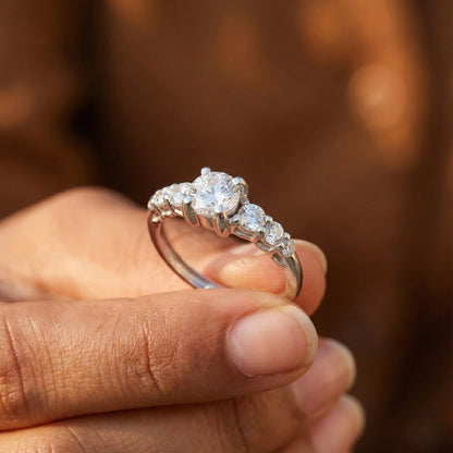 Diamond ring held in a hand with a blurred background