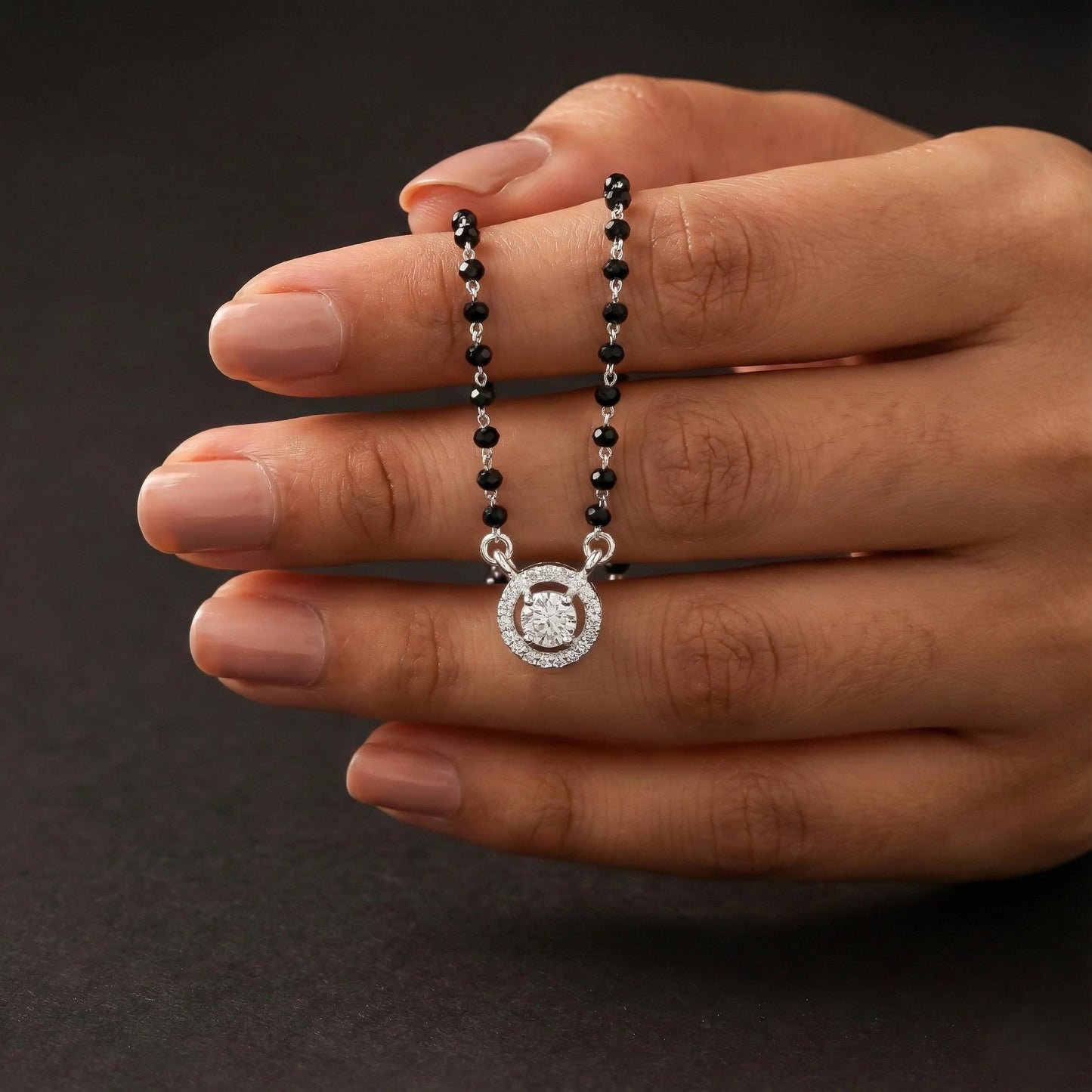 Modern silver mangalsutra featuring black beads and circular pendant