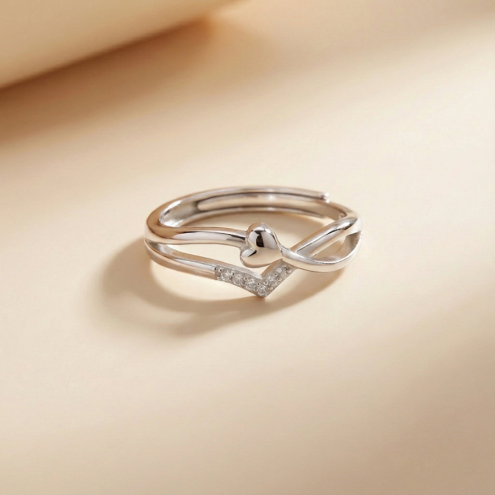 Silver ring with small diamonds on a beige background