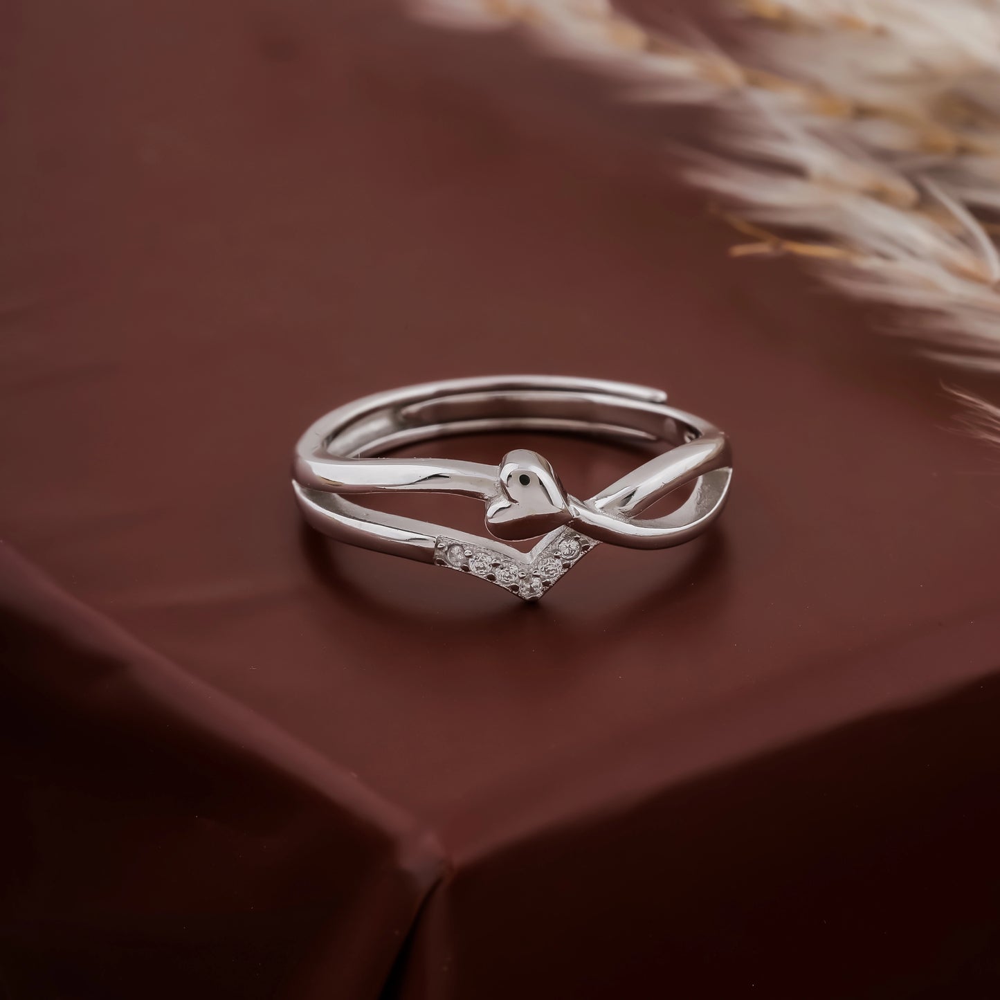 Silver ring with a unique design on a brown fabric background