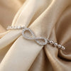 Silver bracelet with an infinity symbol on beige fabric