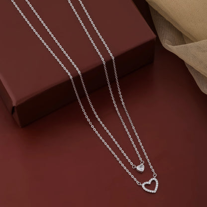 Silver necklace with heart pendants on a brown surface