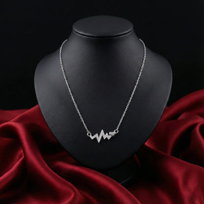 Silver necklace on a black mannequin bust with red fabric underneath