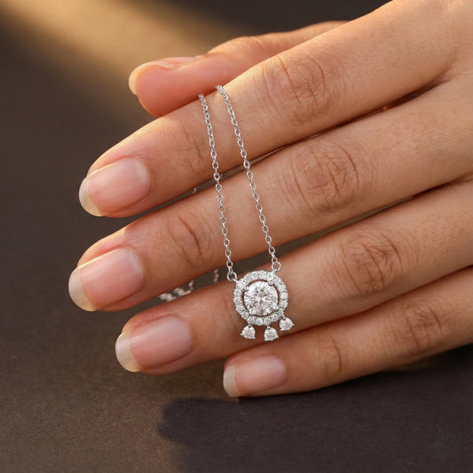 Diamond necklace held by a hand against a dark background