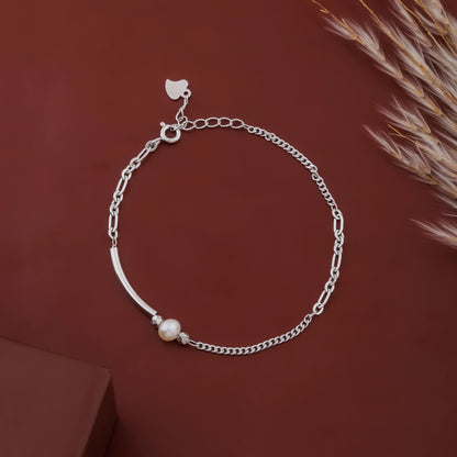 Silver bracelet with a pearl on a brown background