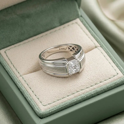 Silver ring with a diamond on a soft green cushion in a jewelry box