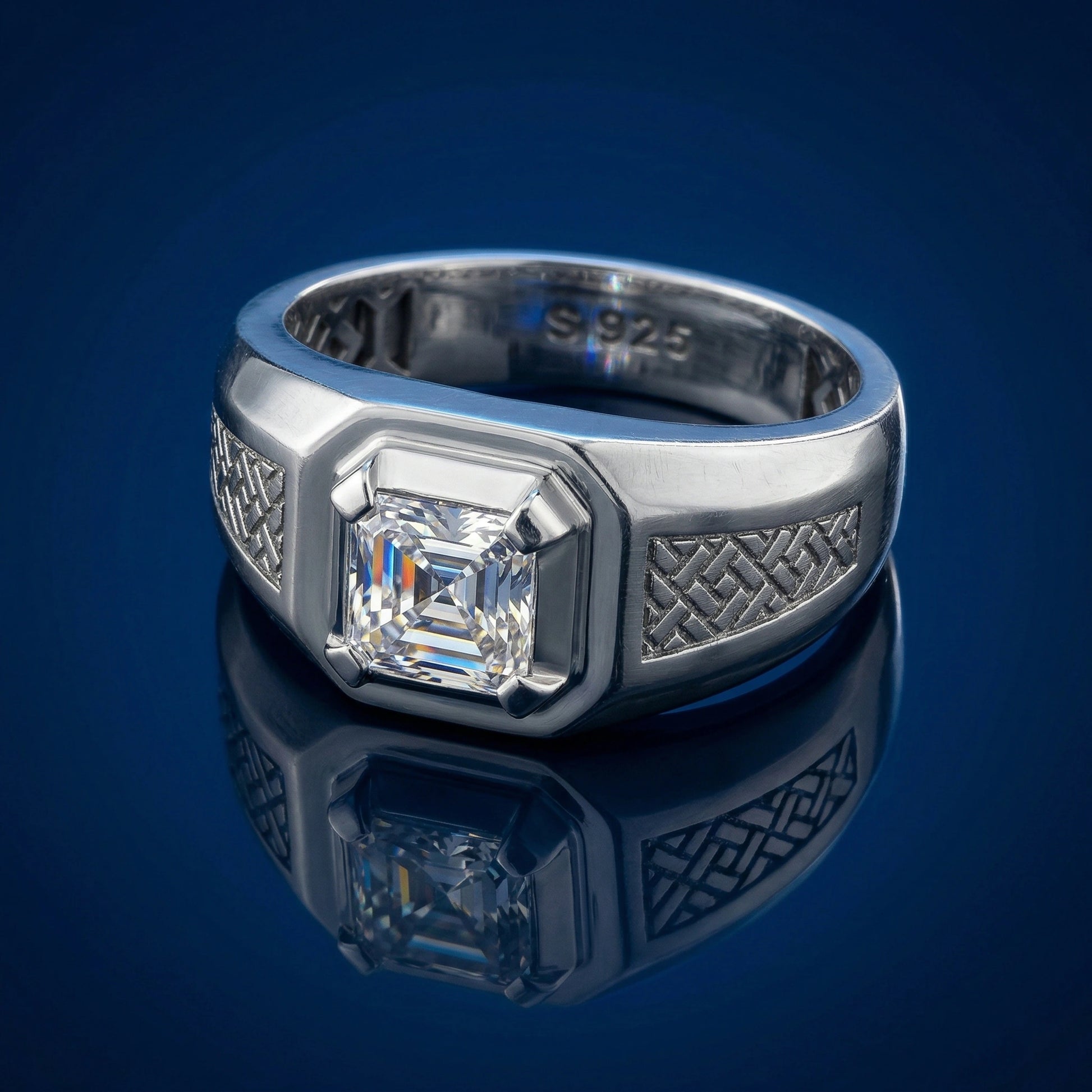 Silver ring with a diamond on a reflective blue surface