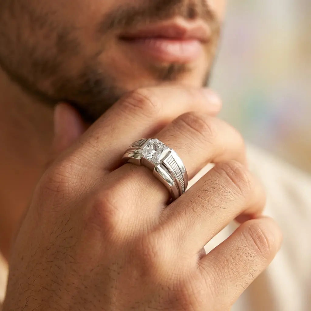 Close-up of a hand wearing a silver ring with a diamond, blurred background