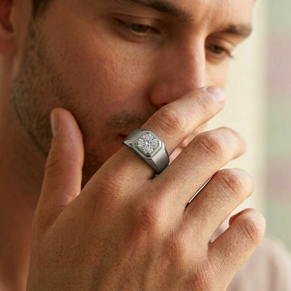 Man wearing a silver ring with a diamond on his finger, close-up shot.