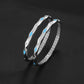 Two silver bracelets with blue accents on a black background