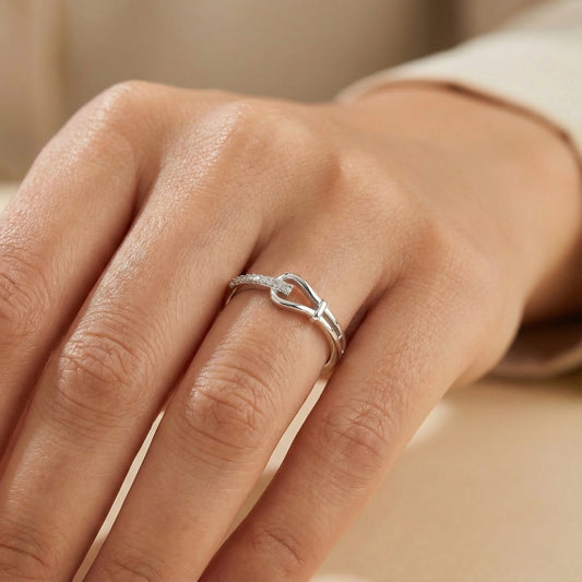Silver ring on a person's finger with a neutral background