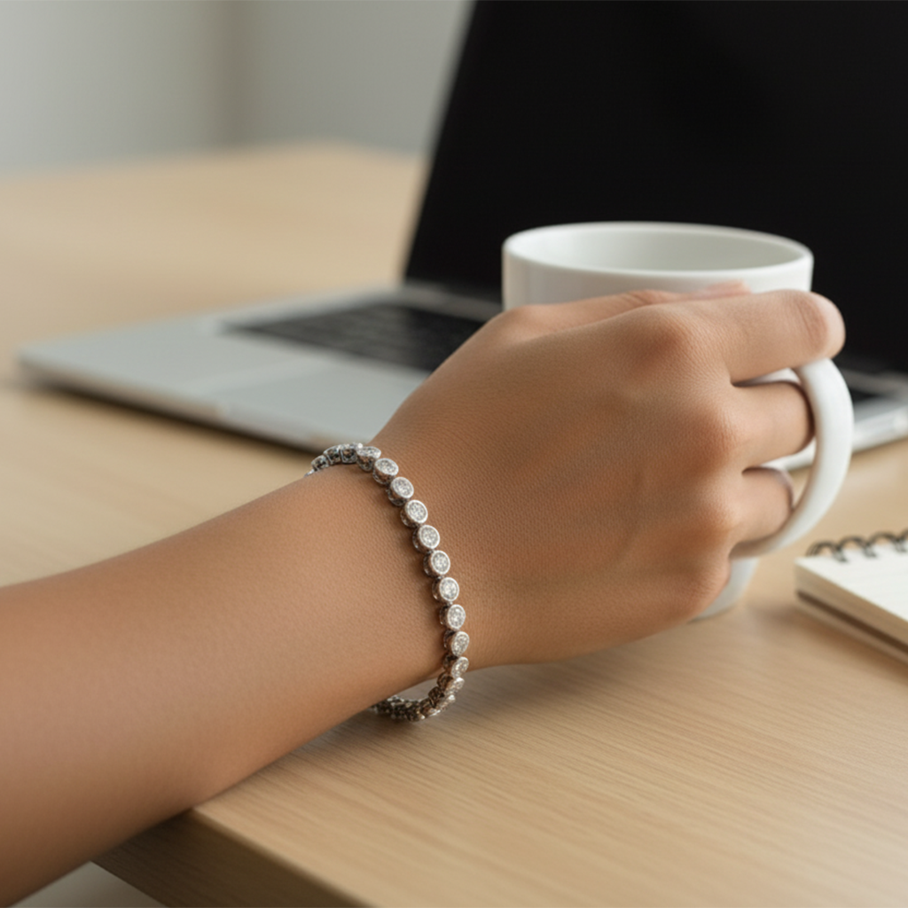 Hand holding a white mug with a laptop in the background