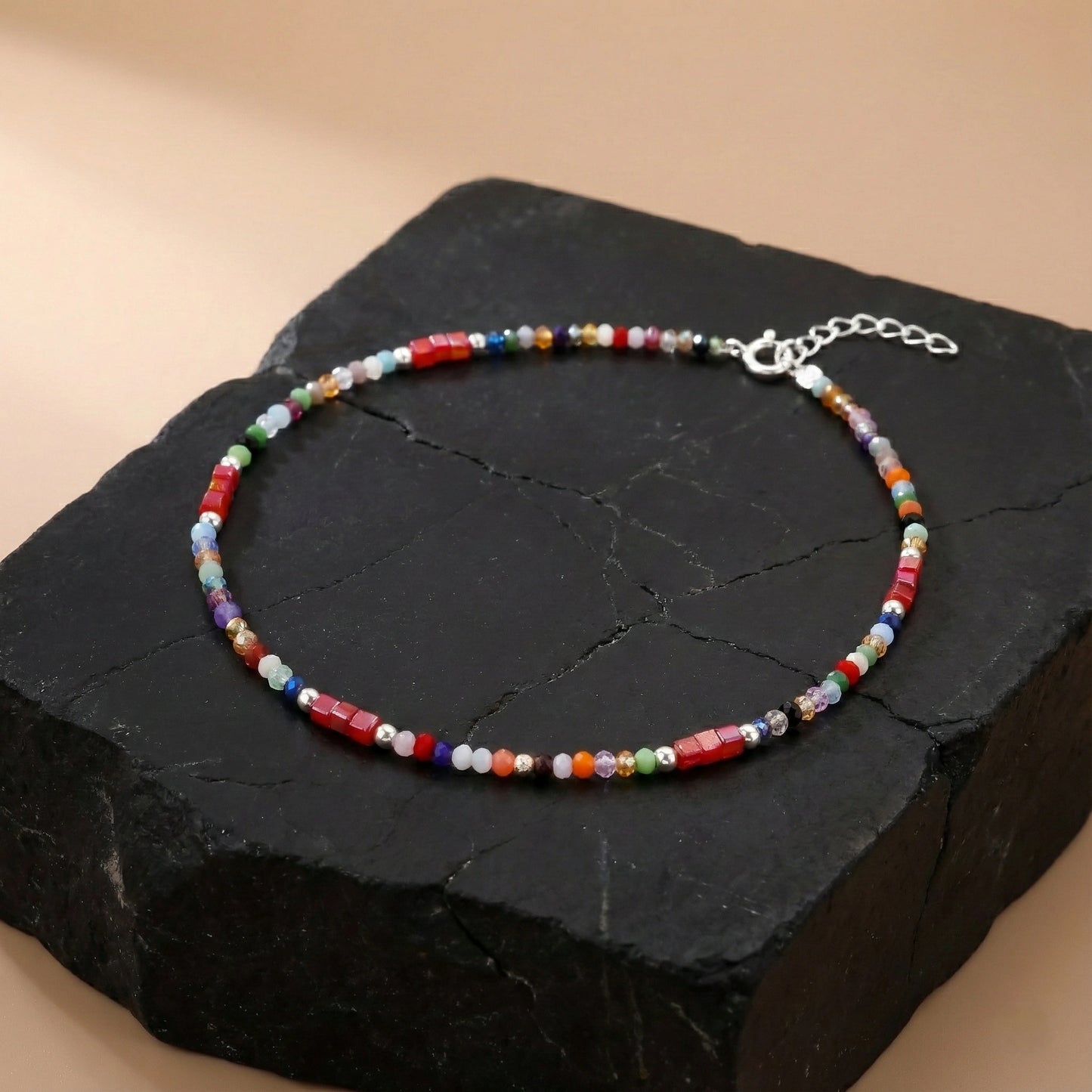 Multicolored beaded bracelet on a black stone surface