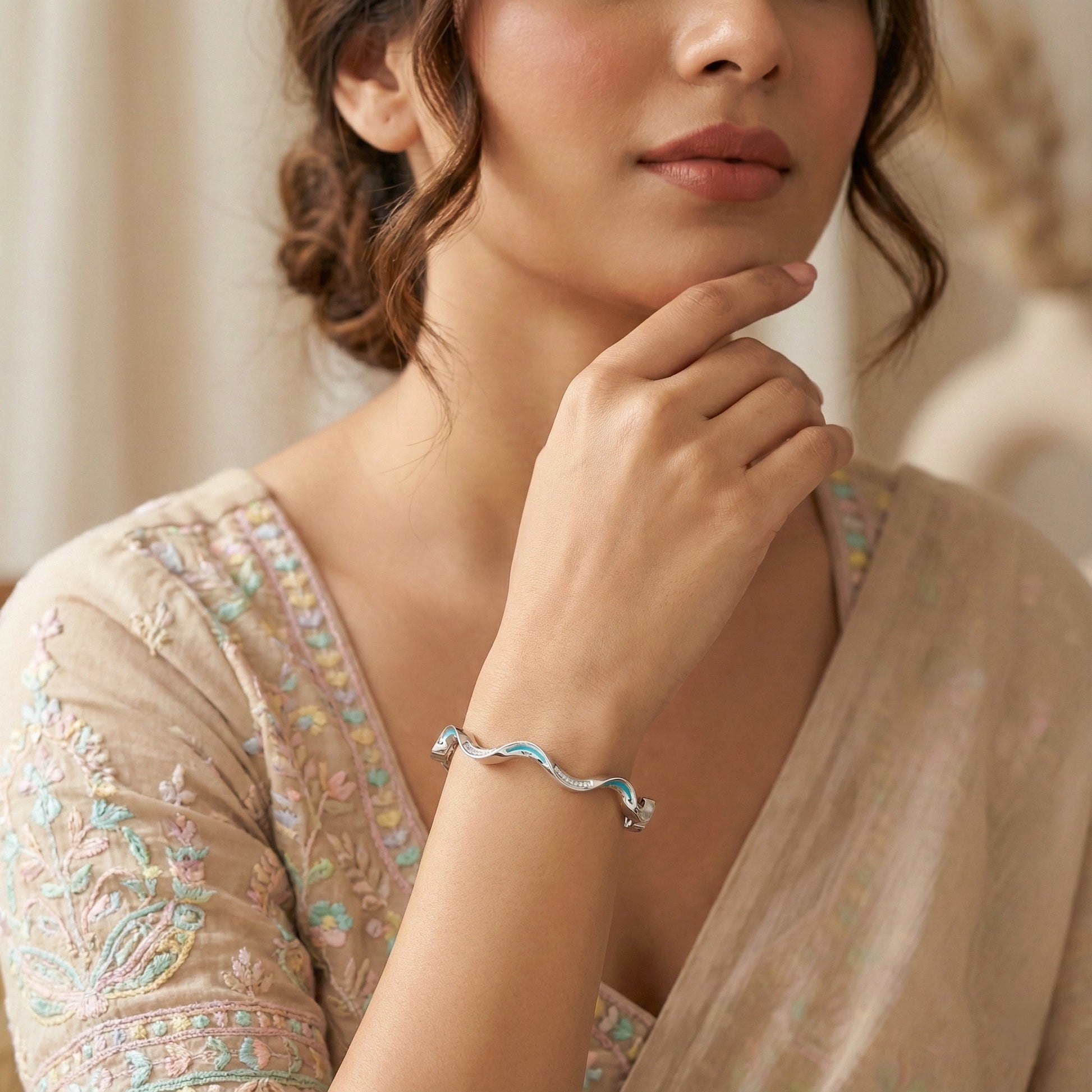 Woman wearing a silver bracelet with a neutral background