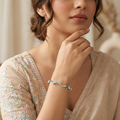 Woman wearing a silver bracelet with a neutral background