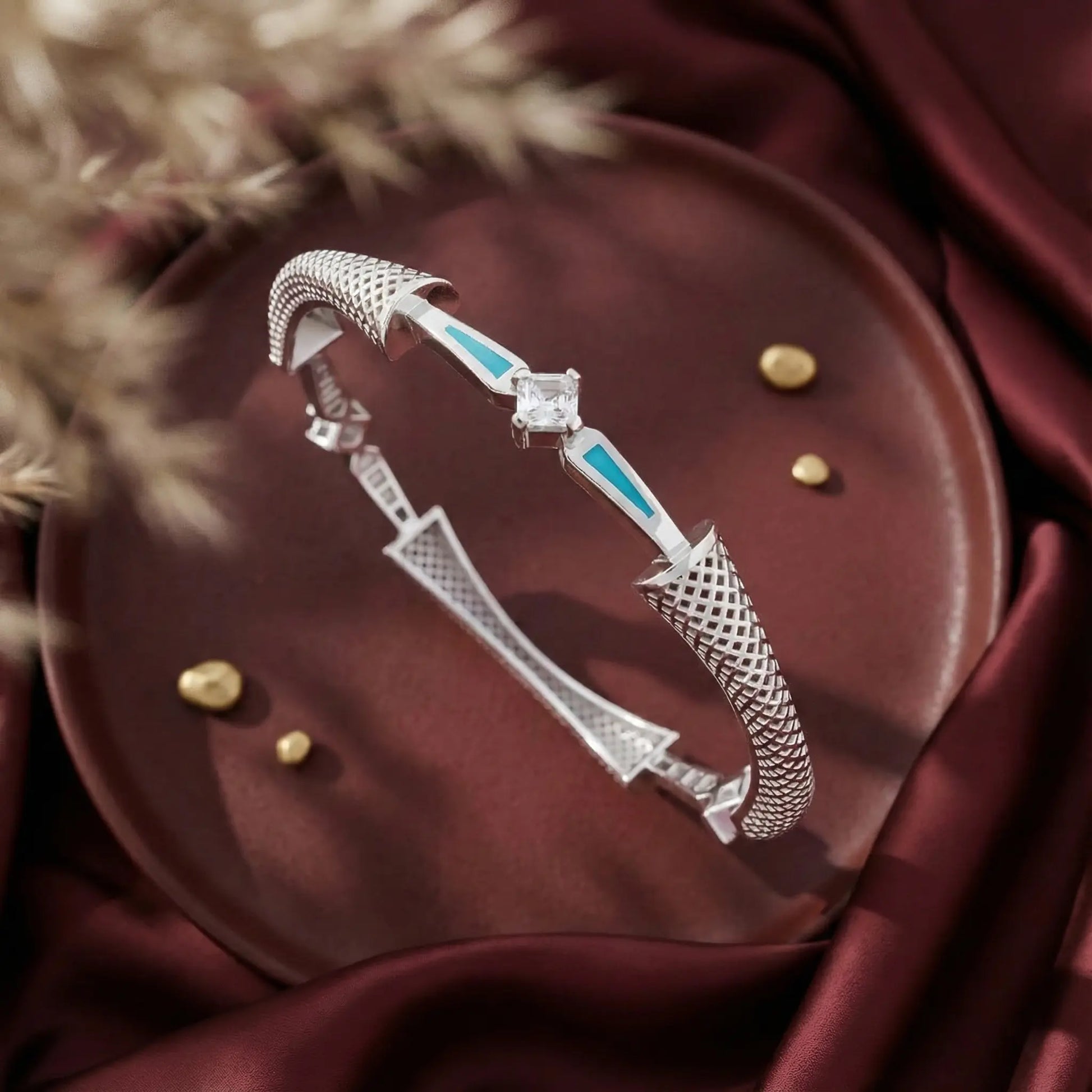 Silver bracelet with turquoise accents on a dark surface