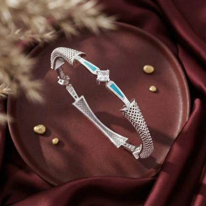 Silver bracelet with turquoise accents on a dark surface