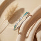 Silver bracelet with turquoise accents on a beige surface with dried grass
