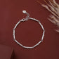 Silver bracelet with heart charm on a brown background