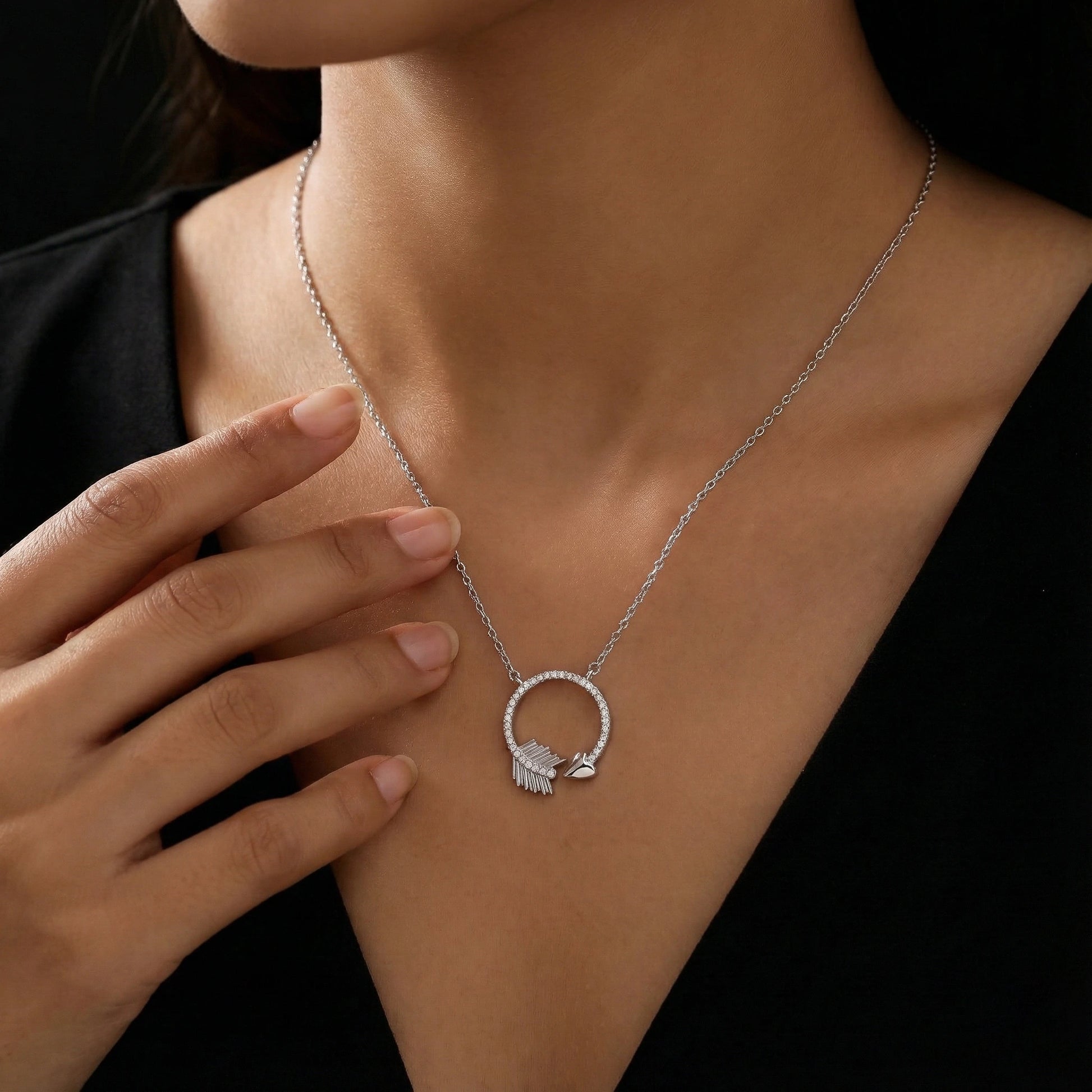 Necklace with a heart-shaped pendant worn by a person against a black background