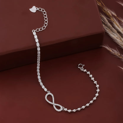 Silver bracelet with heart charm on a brown surface