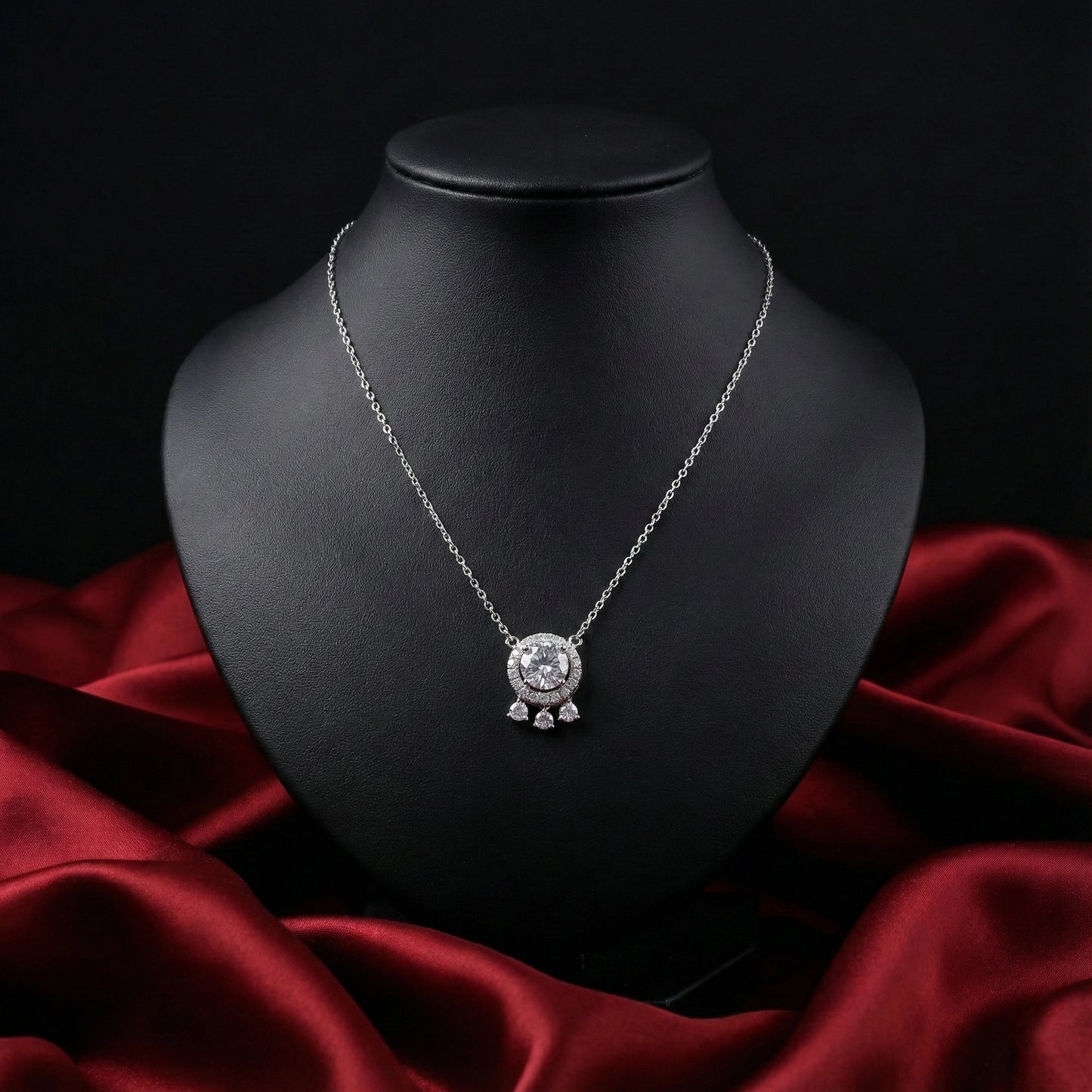 Silver necklace with a round pendant on a black mannequin bust against a dark background