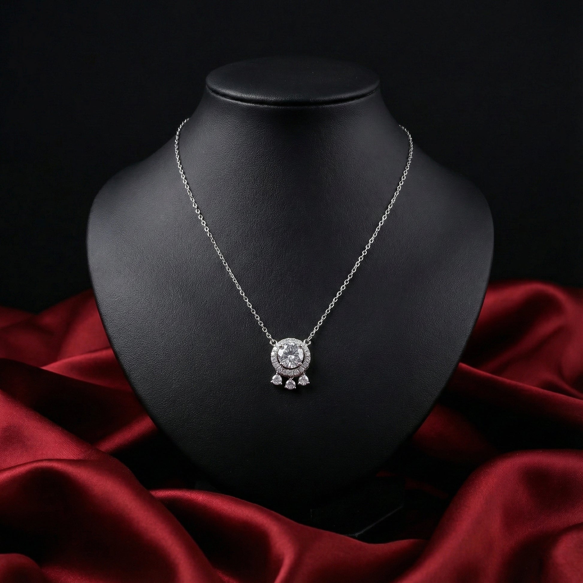 Silver necklace with a round pendant on a black mannequin bust against a dark background