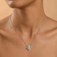 Silver necklace with a star-shaped pendant on a person against a beige background