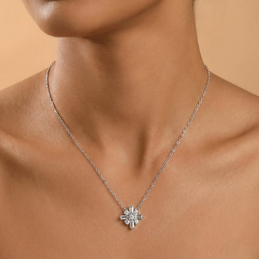 Silver necklace with a star-shaped pendant on a person against a beige background