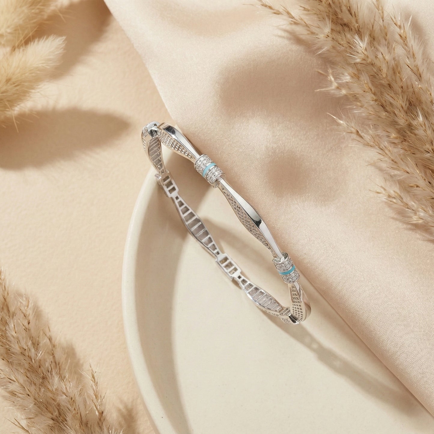 Silver bracelet with turquoise stones on a soft beige fabric background