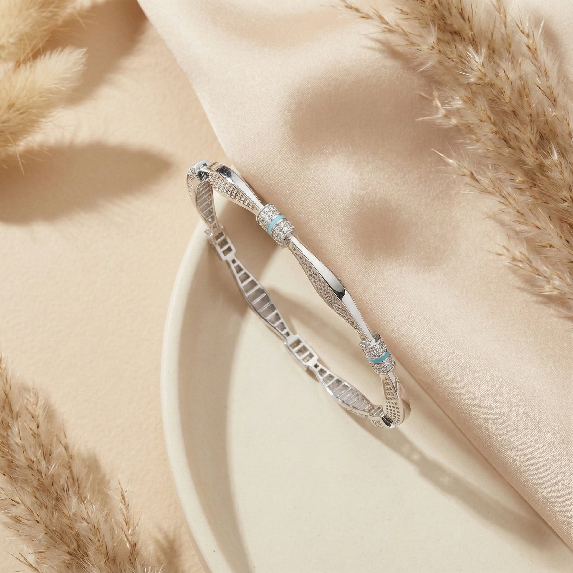 Silver bracelet with turquoise stones on a soft beige fabric background