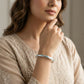 Woman wearing a bracelet with a neutral background