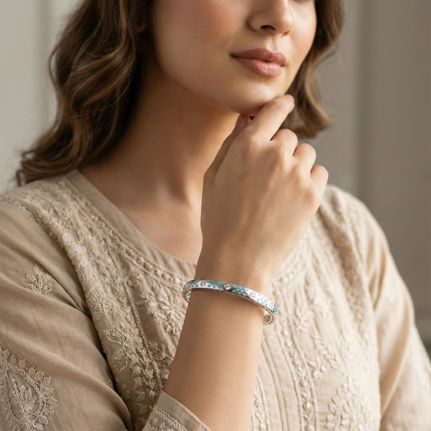 Woman wearing a bracelet with a neutral background