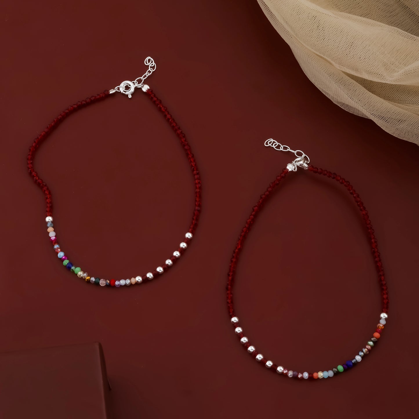 Two beaded bracelets on a dark red background