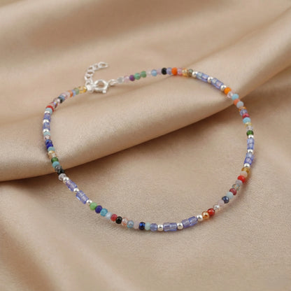 Multicolored beaded bracelet on a beige fabric background