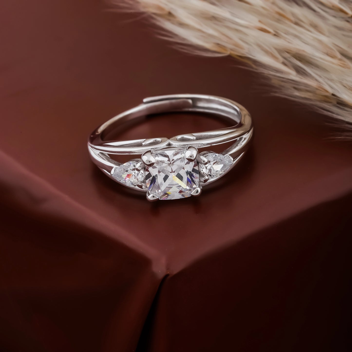 Silver ring with a heart-shaped diamond on a brown surface