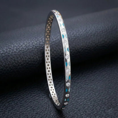 Silver bracelet with blue accents on a dark textured surface