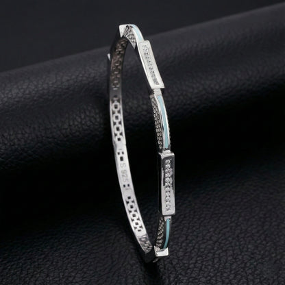 Silver bracelet with decorative elements on a black textured surface