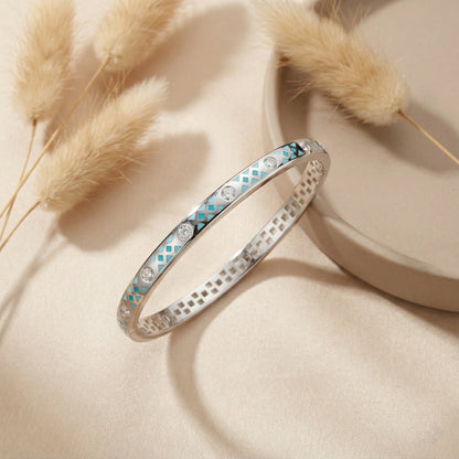 Silver bracelet with gemstones on a beige surface with dried grasses