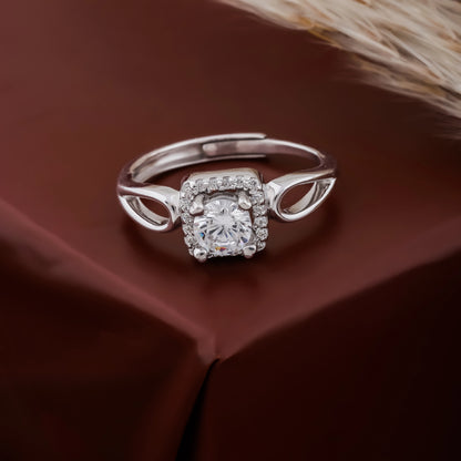 Silver ring with a diamond on a brown fabric background