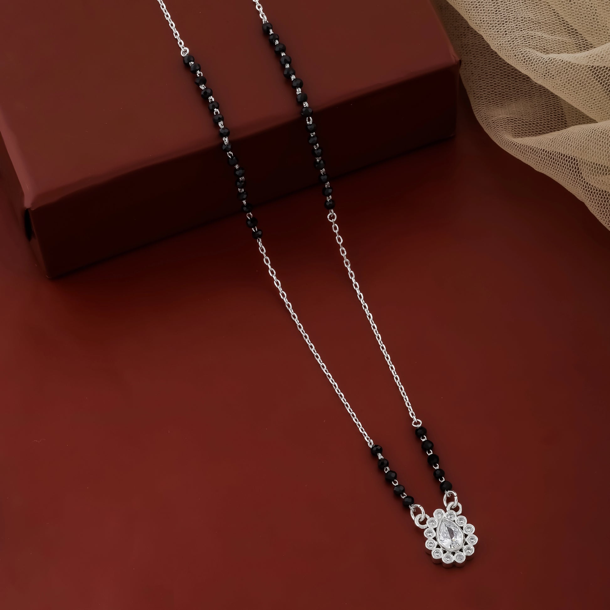 Necklace with a floral pendant on a red surface