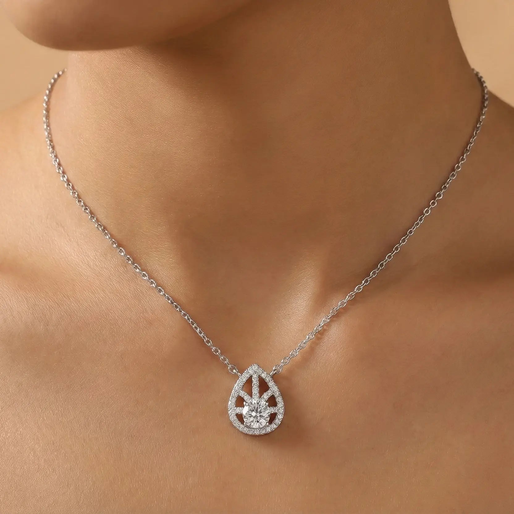Teardrop-shaped diamond necklace on a person's neck