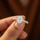 Diamond ring held in a hand with a blurred background