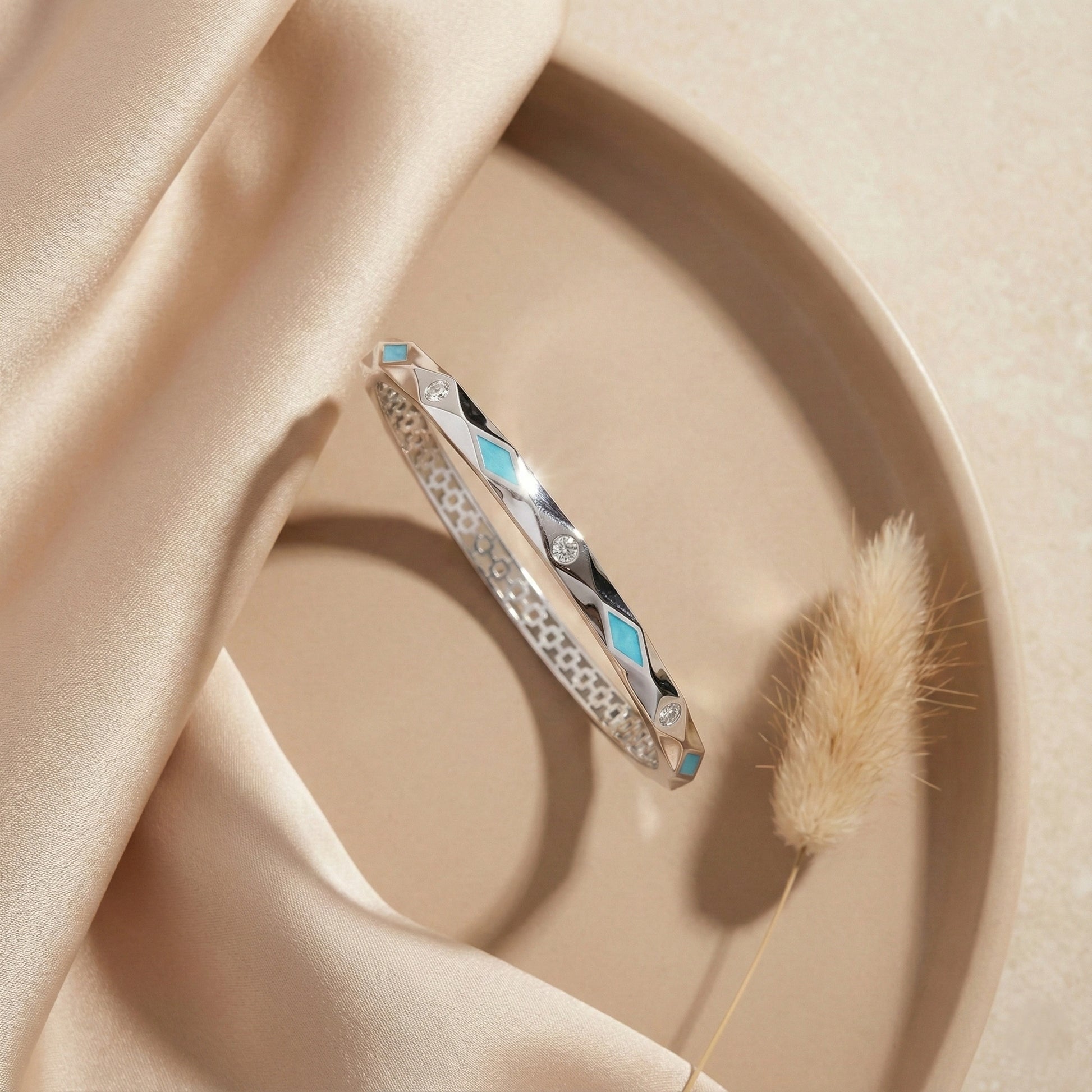 Silver bracelet with turquoise stones on a beige fabric background