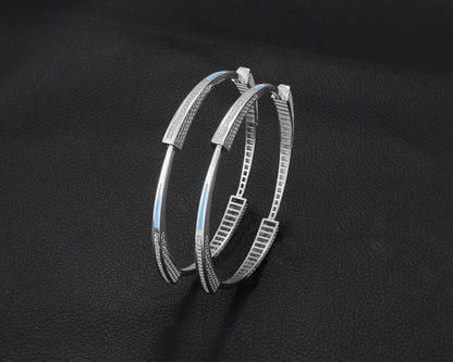 Pair of silver hoop earrings on a dark background