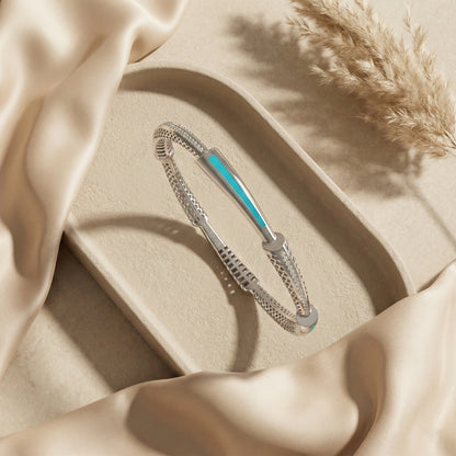 Silver bracelet with a blue accent on a beige fabric background