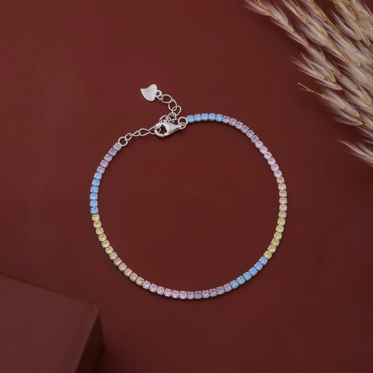 Multicolored beaded bracelet on a brown surface with dried grass