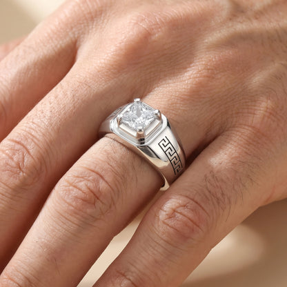 Silver ring with a diamond on a person's finger against a neutral background